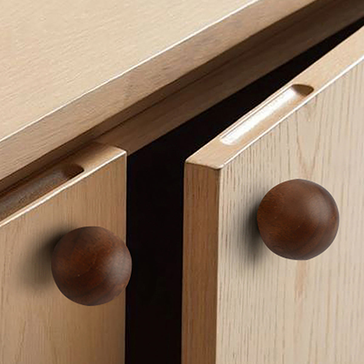 In-use view of round walnut wood cabinet knob, style #1 (30 mm).