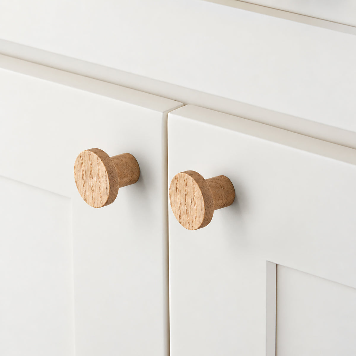 In-use view of flat round white oak cabinet knob, style #1 (33 mm).