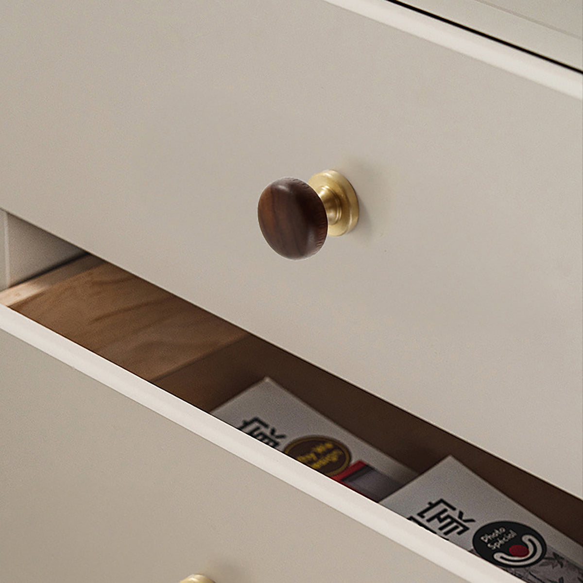 In-use view of dark wood mushroom cabinet knob on a brass pedestal, style #1.