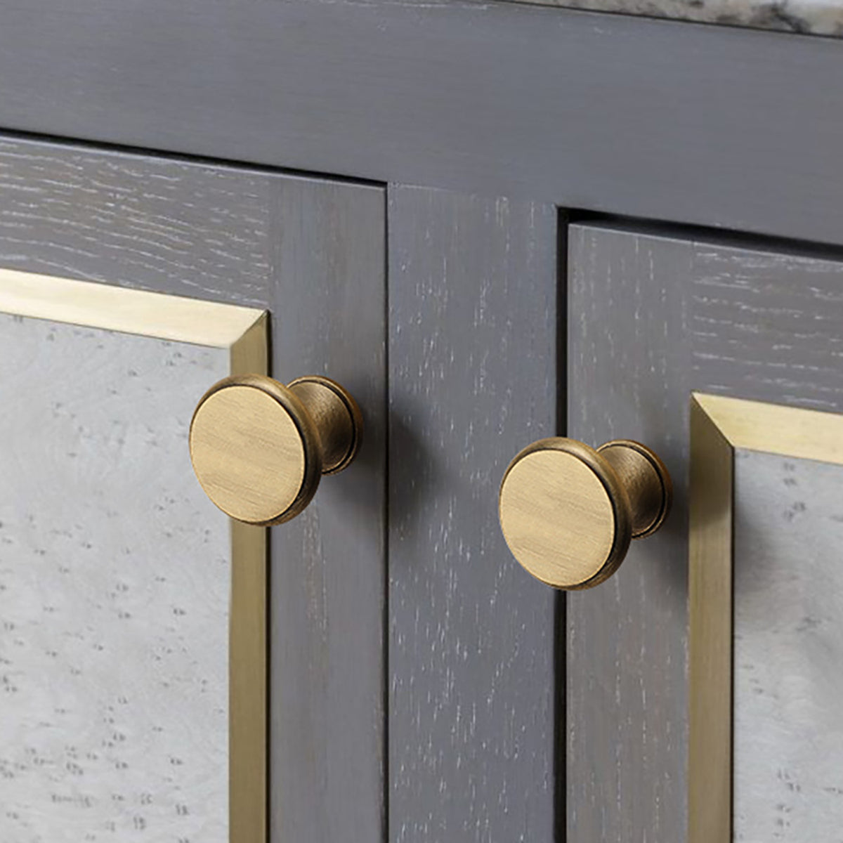 Layered round brass cabinet knob with brushed bronze finish, style #1 installed on furniture.