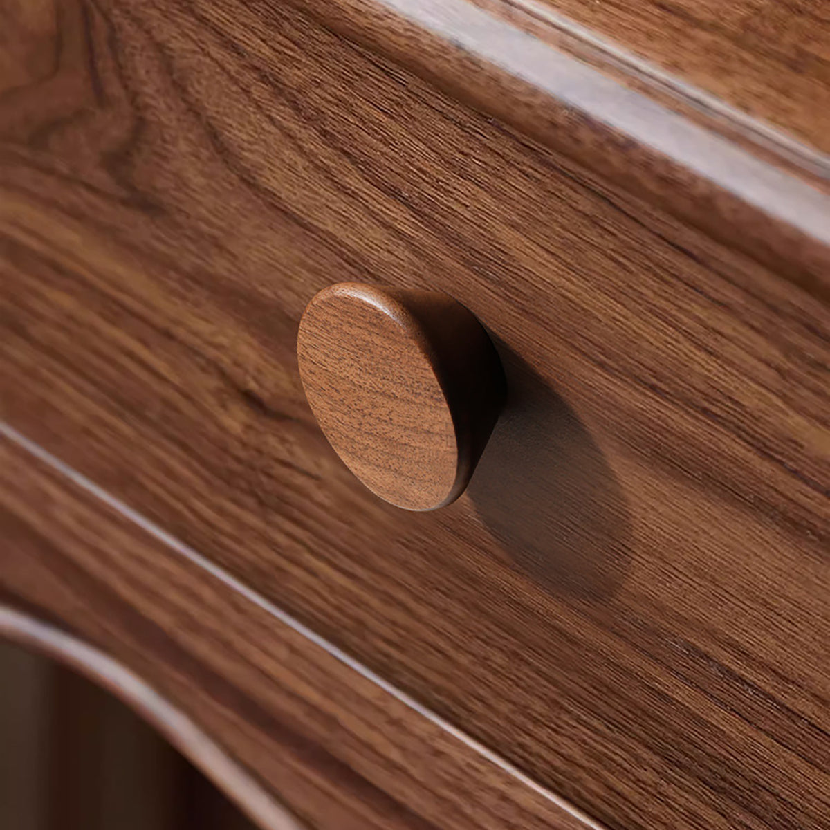 Low-profile round walnut cabinet knob, style #1 shown in a styled setting.
