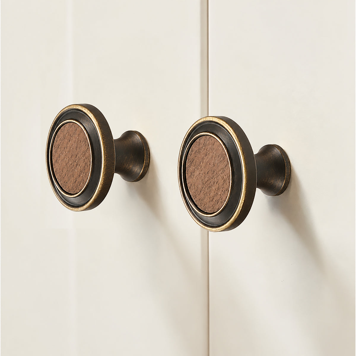 In-use view of flared antique bronze brass cabinet knob with round dark wood inset, style #13.