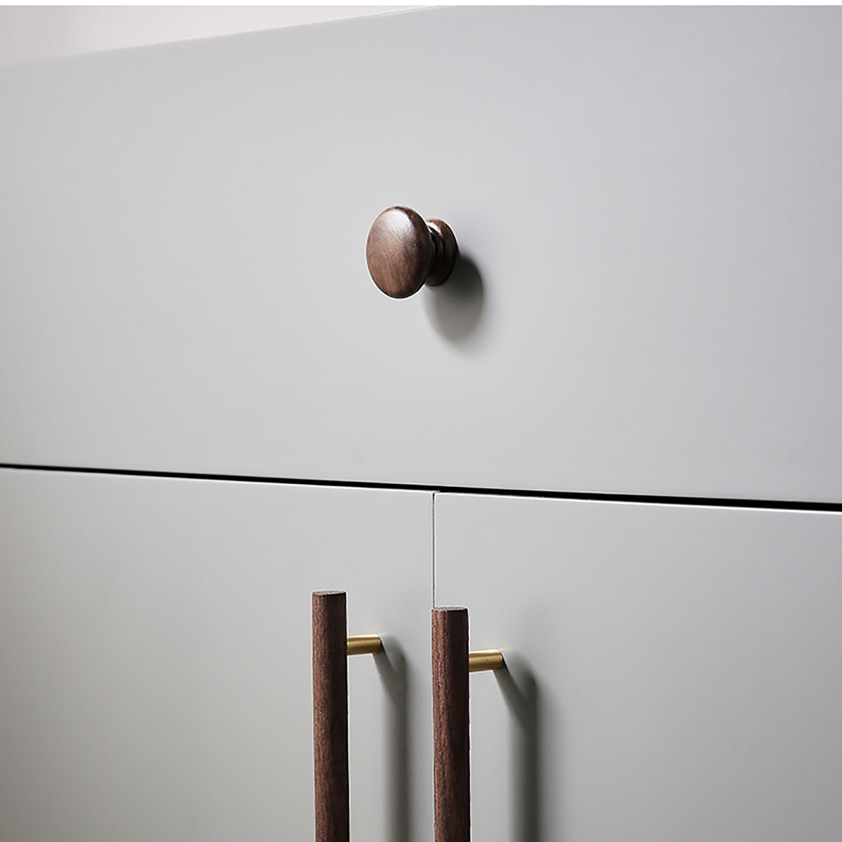 In-use view of turned walnut wood cabinet knob with a stepped round base, style #2.