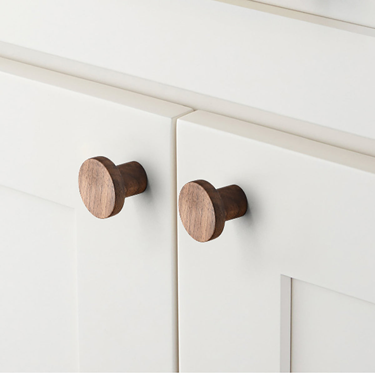 In-use view of flat round walnut wood cabinet knob, style #3 (33 mm).