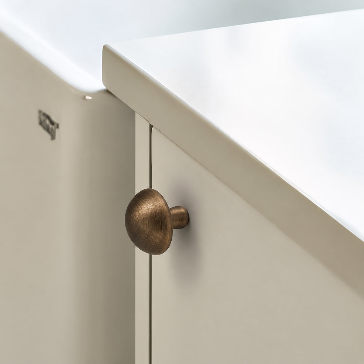 Bronze-finish solid brass round cabinet knob, style #4 shown in a styled setting.