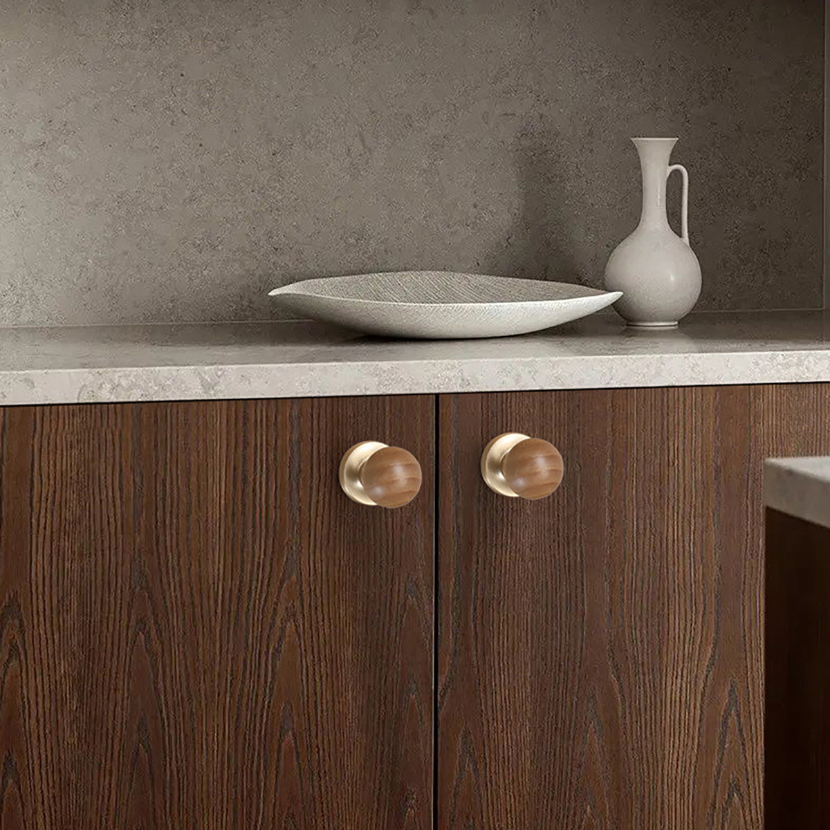 In-use view of rounded oak wood cabinet knob with brass base, style #5.