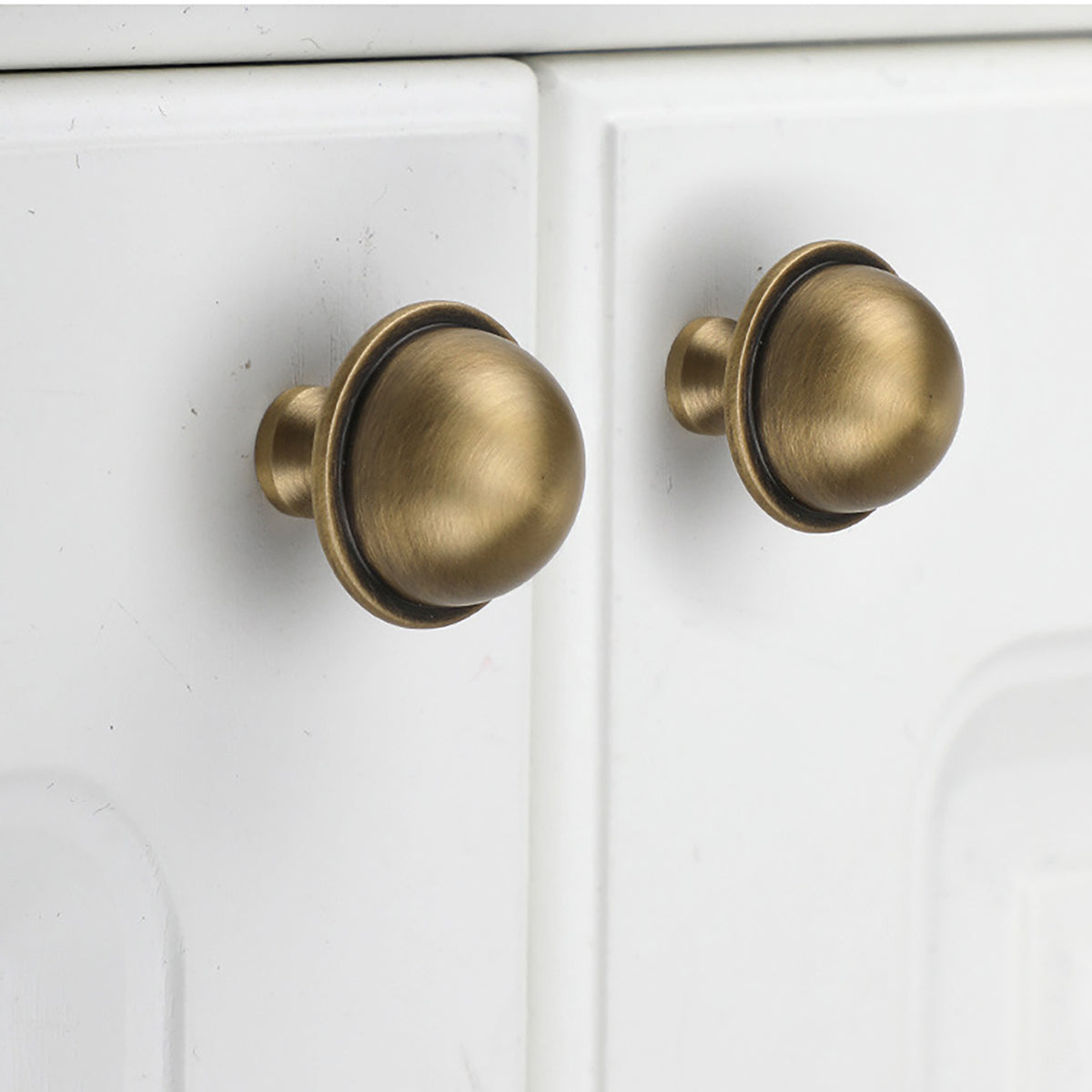 Half-dome brass cabinet knob with brushed bronze finish, style #7 installed on furniture.