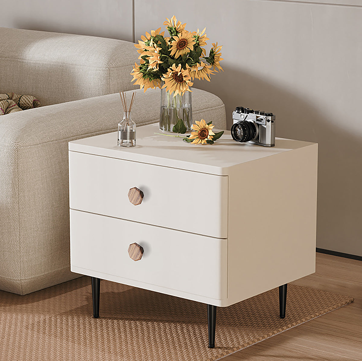 Two faceted beech wood cabinet knobs on a white bedside table.
