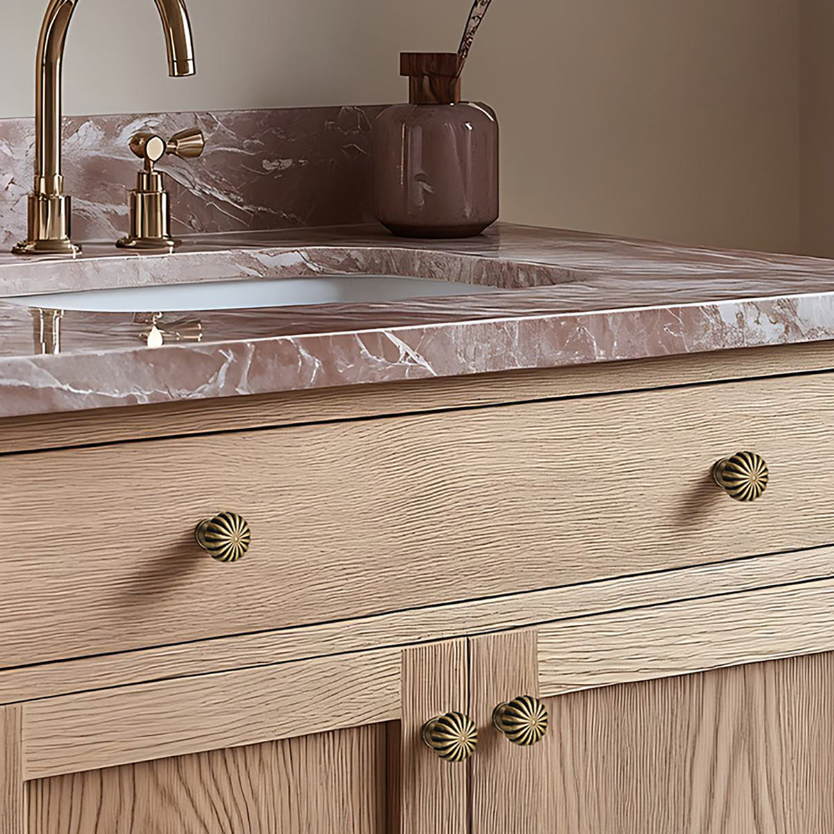 Fluted bronze-finish brass cabinet knobs installed on a pale wood bathroom vanity.