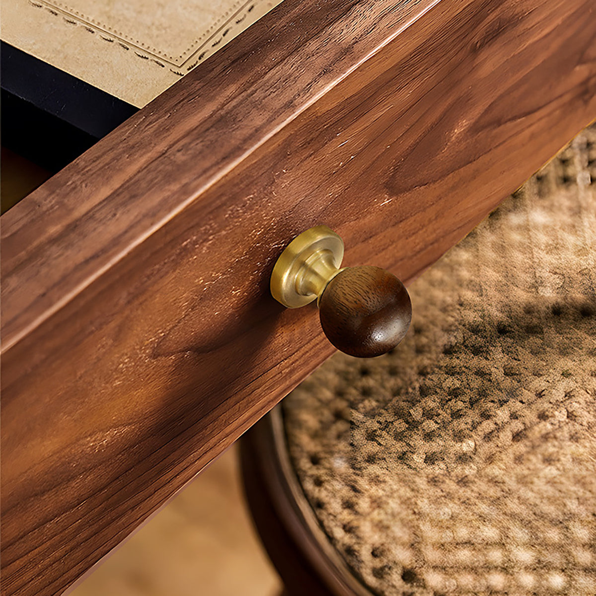 Brass cabinet knob with dark wood ball inset installed on a walnut cabinet drawer.
