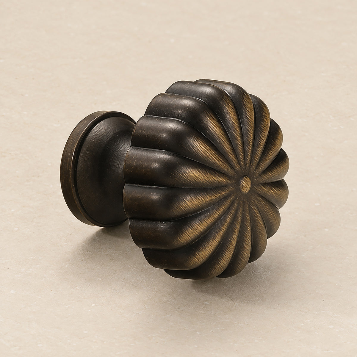 Fluted flower-shaped bronze-finish brass cabinet knob from the side.