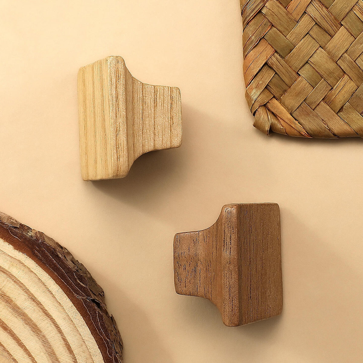 Flared square wood cabinet knobs in natural and dark finishes beside a woven basket.