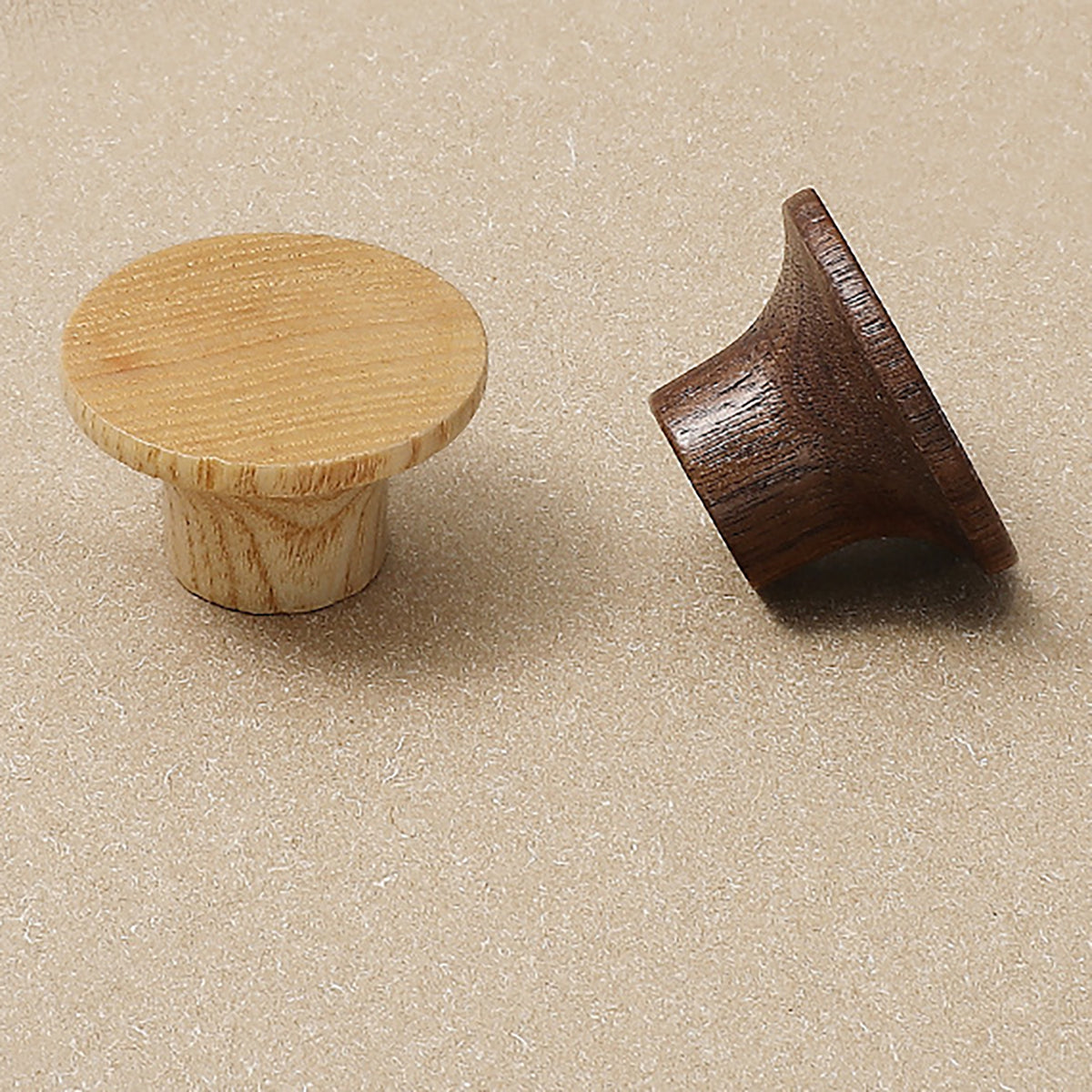 Round wood cabinet knobs in natural and walnut finishes, shown from front and side.
