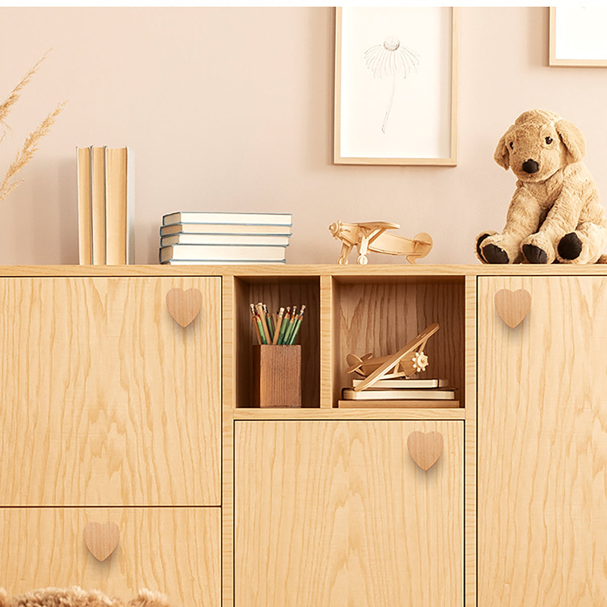 Heart-shaped wood knobs on a light-wood storage cabinet.