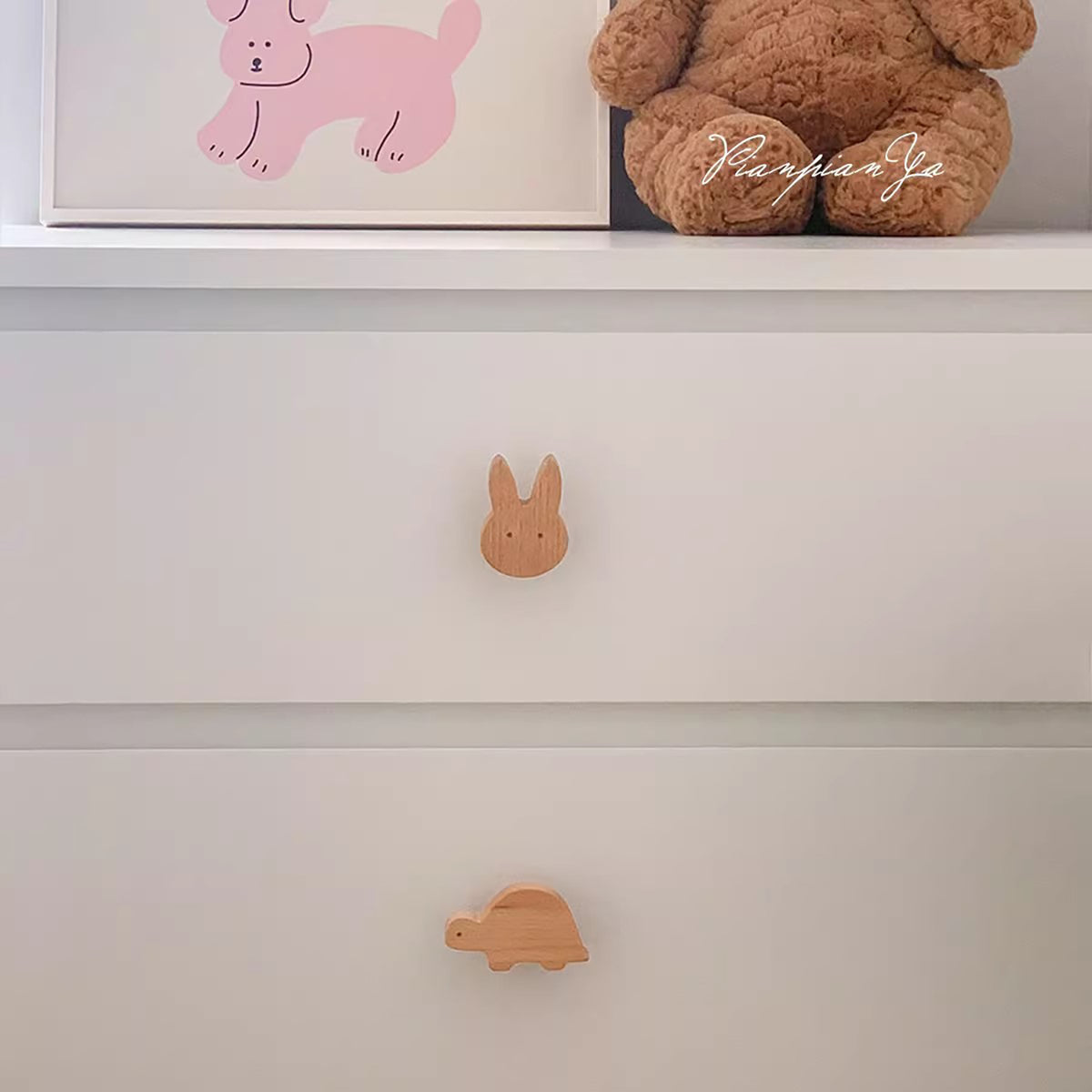 Rabbit-shaped wood knob on a white chest drawer.