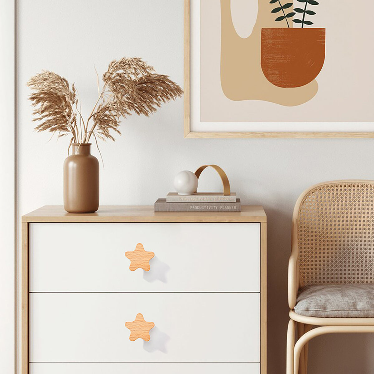 Star-shaped wood knobs on white chest drawers.