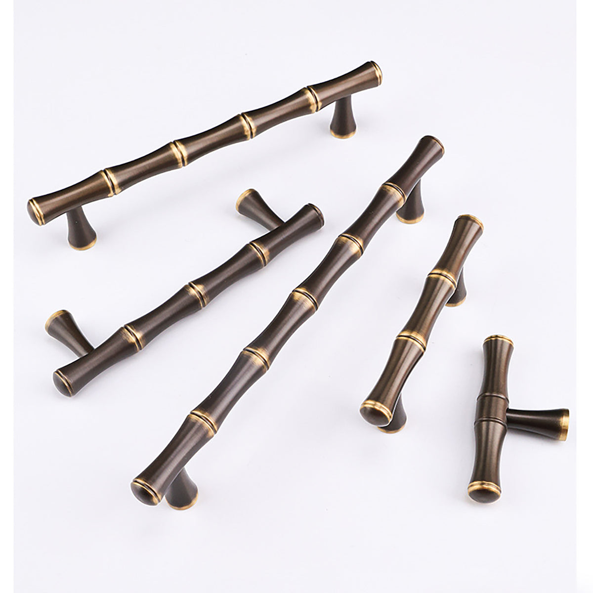 Dark antique brass bar and T-bar cabinet pulls with matching gold ring details.