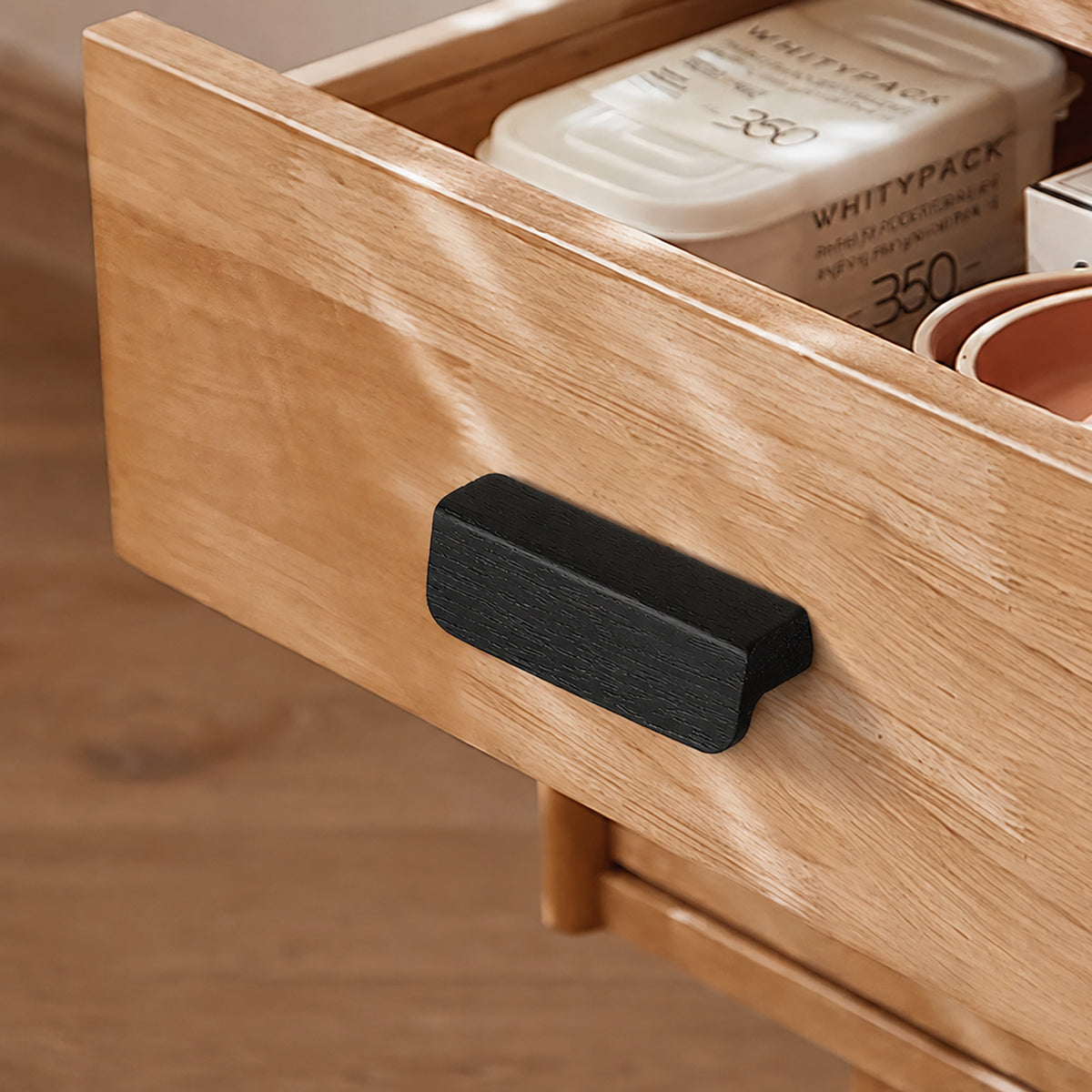 Black-finish oak wood cabinet finger pull, style #2 (32 mm option) fitted to cabinetry.