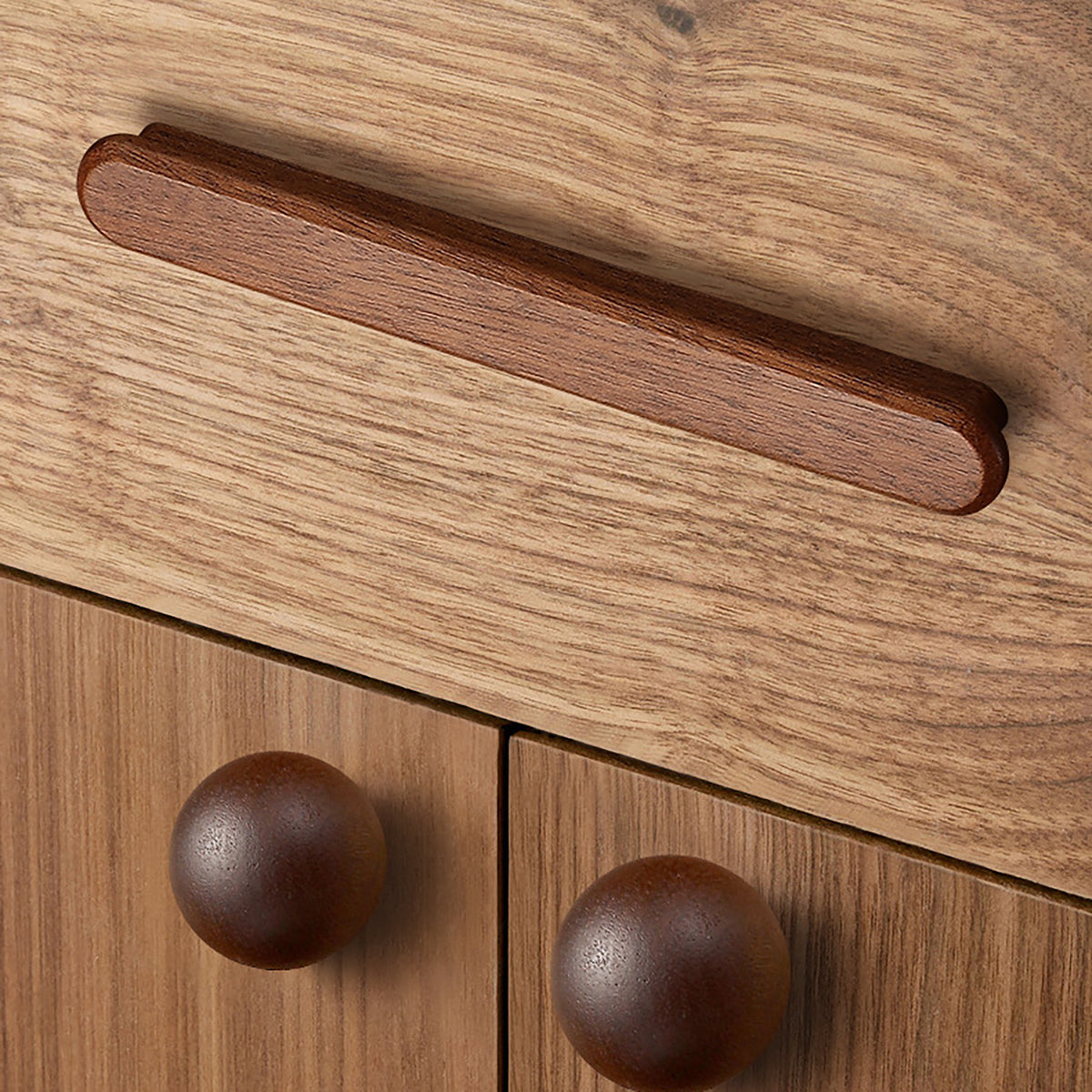 In-use view of slim rounded reddish wood finger pull, 96 mm option.