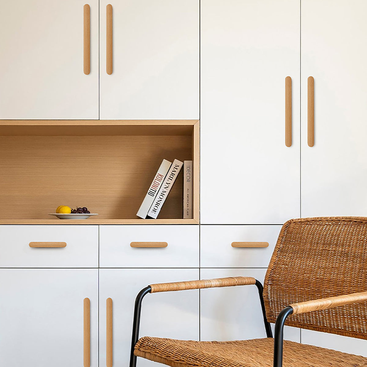 Long beech wood finger pulls installed on natural wood cabinet doors.