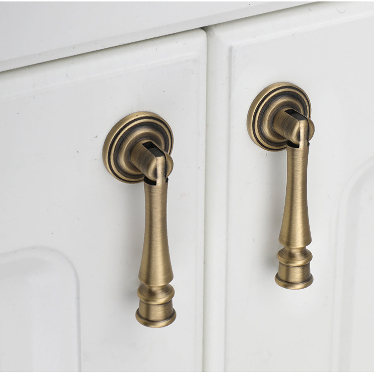 Swinging bar brass drop pull with brushed bronze finish, style #11 installed on furniture.