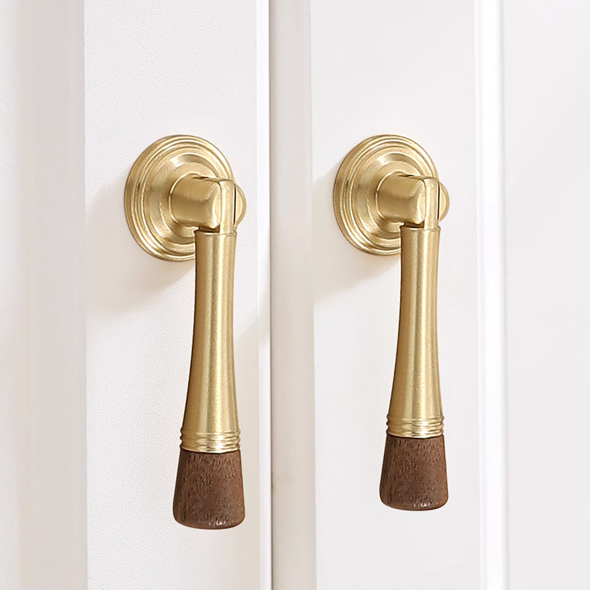 In-use view of dark wood-ended brass drop pull with round mounting plate, style #7 Brass (76 mm).