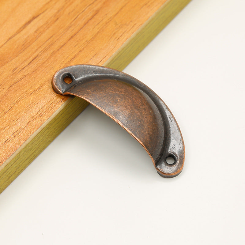 Raised-rim half-moon iron cup pull in Antique Copper, angled front view with two mounting holes.