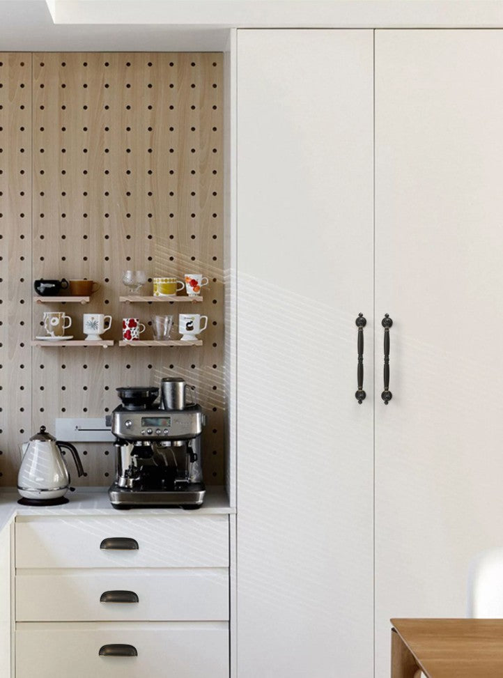 Solid brass rounded dome cup pulls in Antique Bronze on white kitchen drawers beside a coffee station.