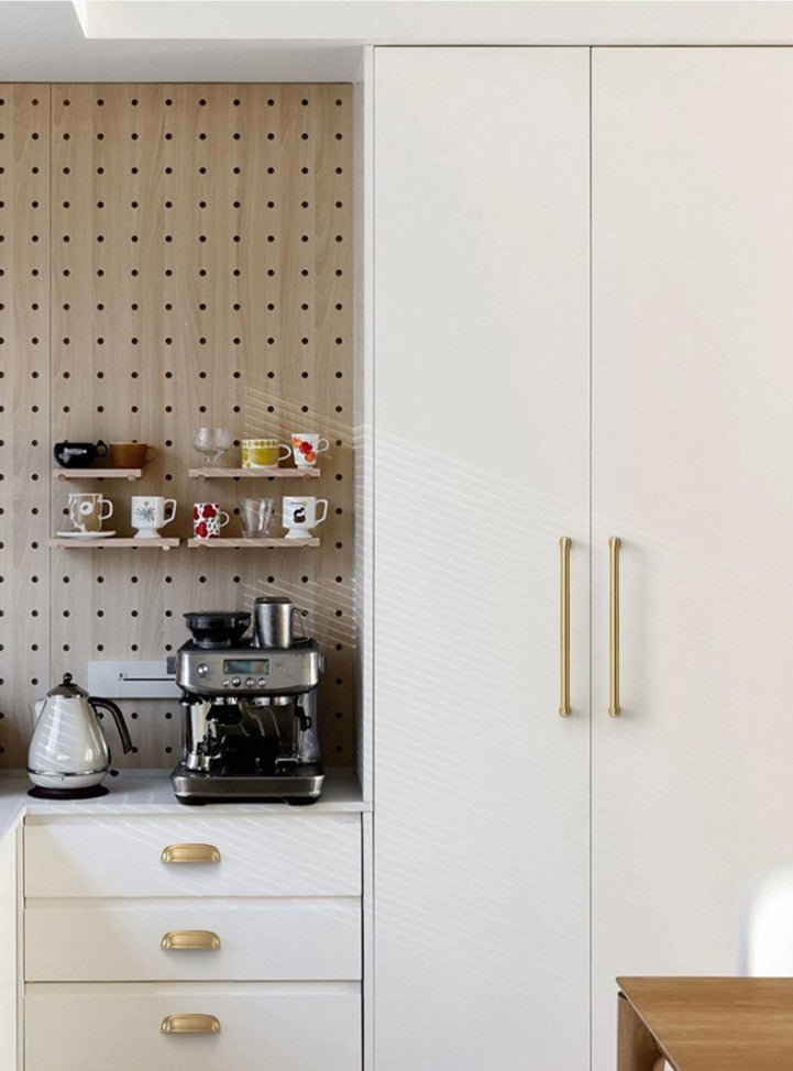 Solid brass rounded dome cup pulls in Satin Brass on white kitchen drawers beside a coffee station.
