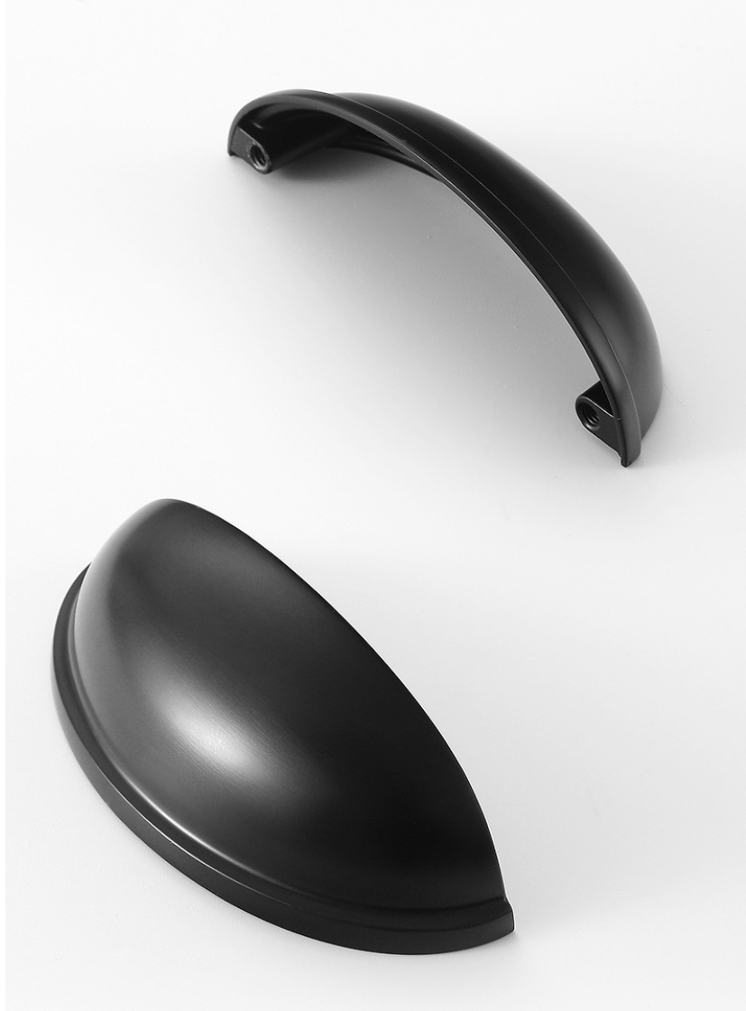 Two matte black half-moon cup pulls showing the curved front and underside with mounting holes.