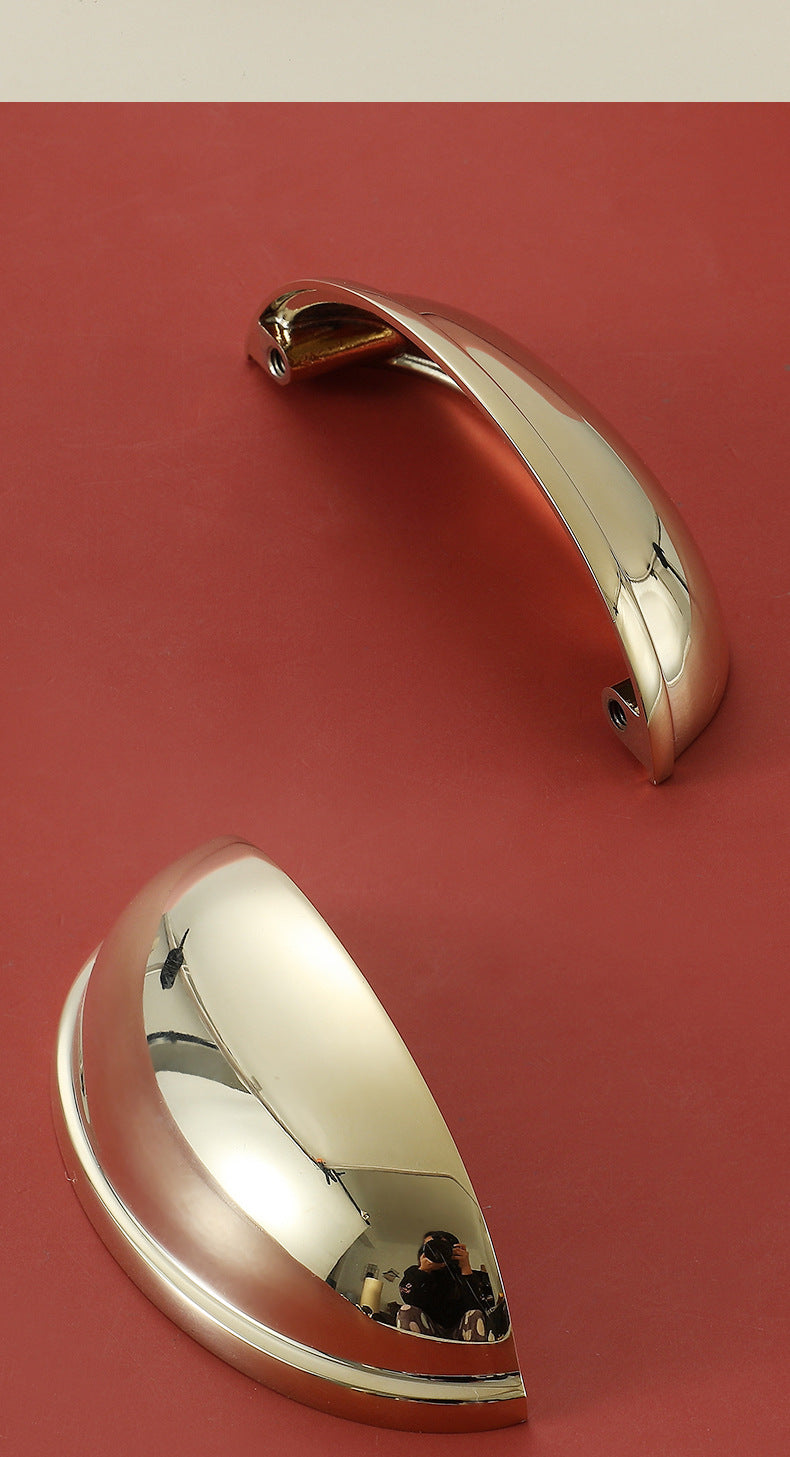Two polished gold half-moon cup pulls showing the curved front and underside with mounting holes.