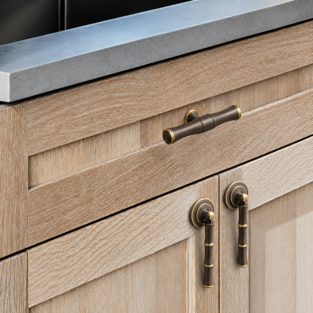 In-use view of segmented dark antique brass T-bar cabinet pull with gold rings, style #11.