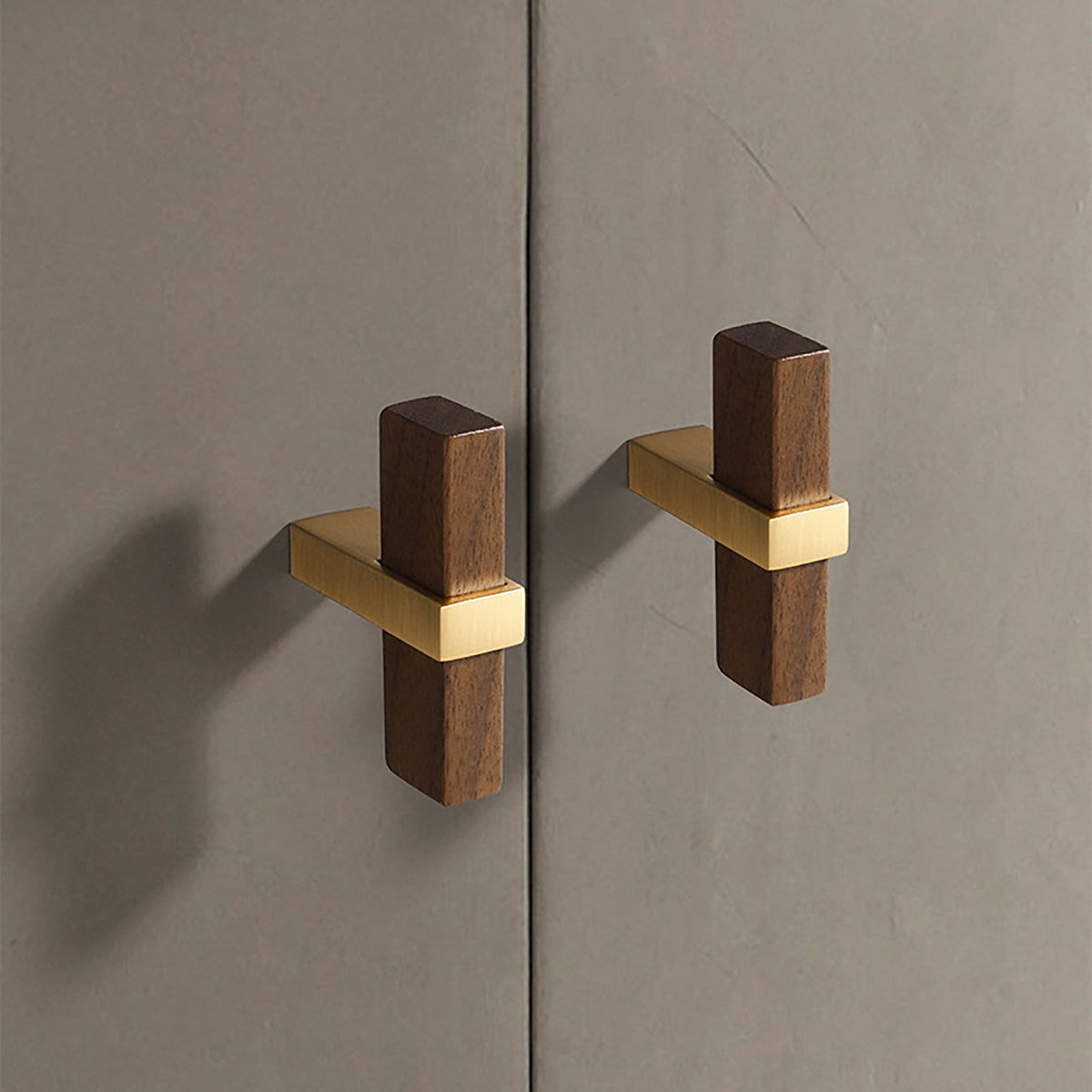 In-use view of walnut wood T-bar cabinet pull with a square brass center mount, style #2.