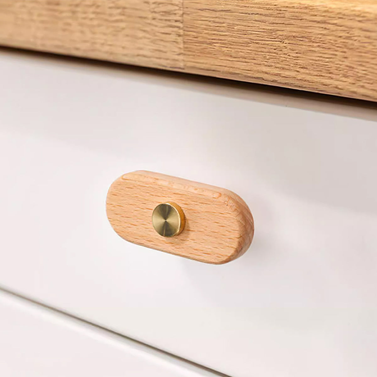 In-use view of oval beech wood T-bar cabinet pull with brass stem and top stud, style #7.