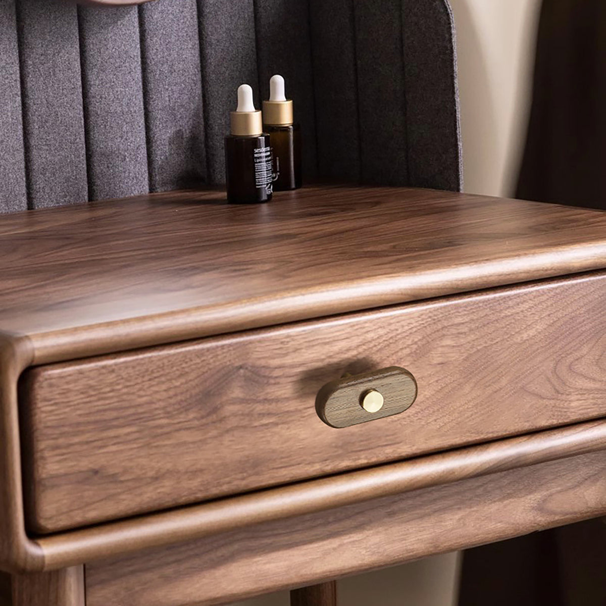 In-use view of oval walnut wood T-bar cabinet pull with brass stem and top stud, style #7.