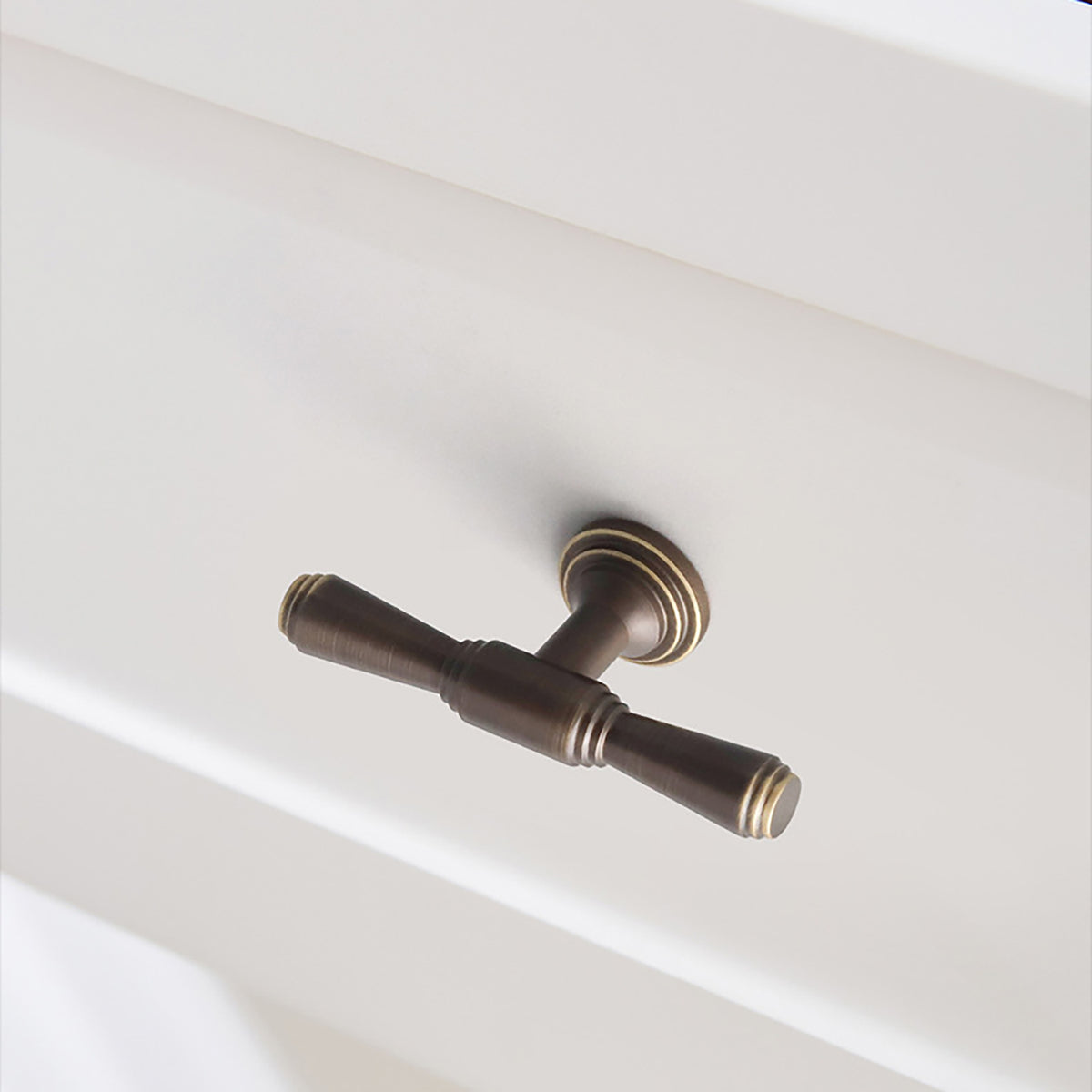 In-use view of dark antique brass T-bar cabinet pull with flared ends, style #9.